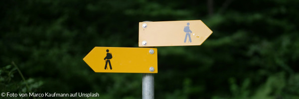 Zwei Wegweiser, die in verschiedene Richtungen weisen
